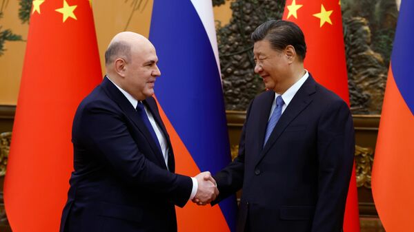 Russian Prime Minister Mikhail Mishustin and Chinese President Xi Jinping shake hands before a meeting in Beijing, China, on Wednesday, December 20, 2023. - Sputnik Africa