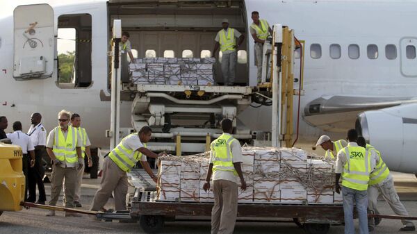 Some 10 tonnes of relief food from the World Food Programme (WFP) is unloaded after landing in Mogadishu airport, Wednesday July 27, 2011. - Sputnik Africa