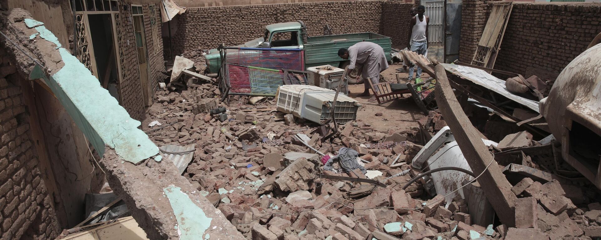 A man cleans debris of a house hit in recent fighting in Khartoum, Sudan, Tuesday, April 25, 2023.  - Sputnik Africa, 1920, 23.12.2023