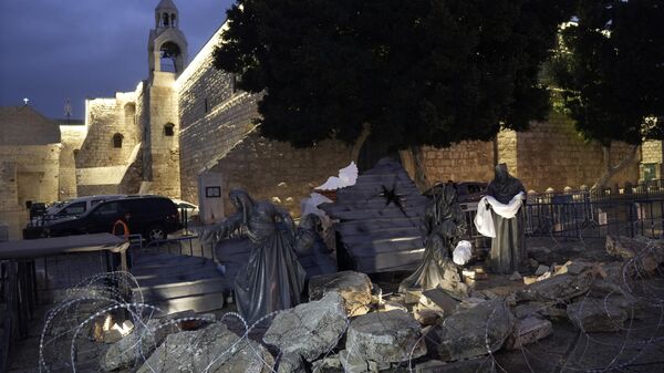 A nativity scene with rubble around symbolizing the destruction in Gaza and white sheets referring to the dead civilians, is dispalyed in Manger Square next to the Church of the Nativity, in the West Bank town of Bethlehem - Sputnik Africa