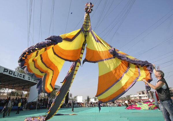 A German competitor, right, flies his 16 meter long (52 foot) dragon shaped kite as people watch during the International Kite Festival in Ahmadabad, India, Saturday, Jan. 12, 2008.  - Sputnik Africa