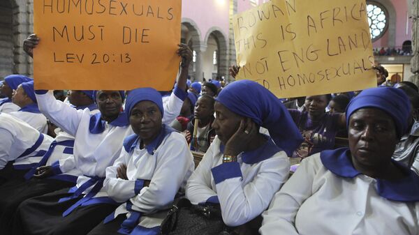 Members of Anglican church supporting Zimbabwe Bishop Nolbert Kunongas hold placards attacking homosexuality and condemning the visit by Britain's Archbishop of Canterbury Rowan Williams, in Harare, Zimbabwe, on Sunday Oct. 9, 2011.   - Sputnik Africa
