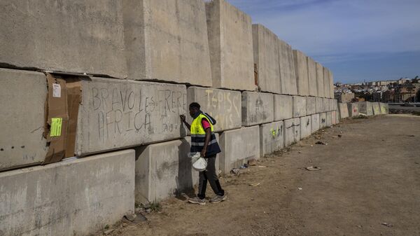 A sub-Saharan migrant writes his name on the breakwater in the Spanish enclave of Ceuta, Friday, May 21, 2021. - Sputnik Africa