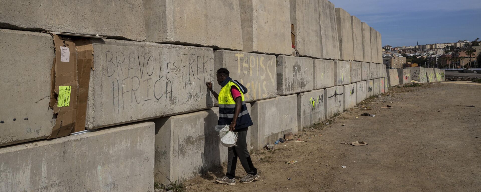 A sub-Saharan migrant writes his name on the breakwater in the Spanish enclave of Ceuta, Friday, May 21, 2021. - Sputnik Africa, 1920, 31.12.2023