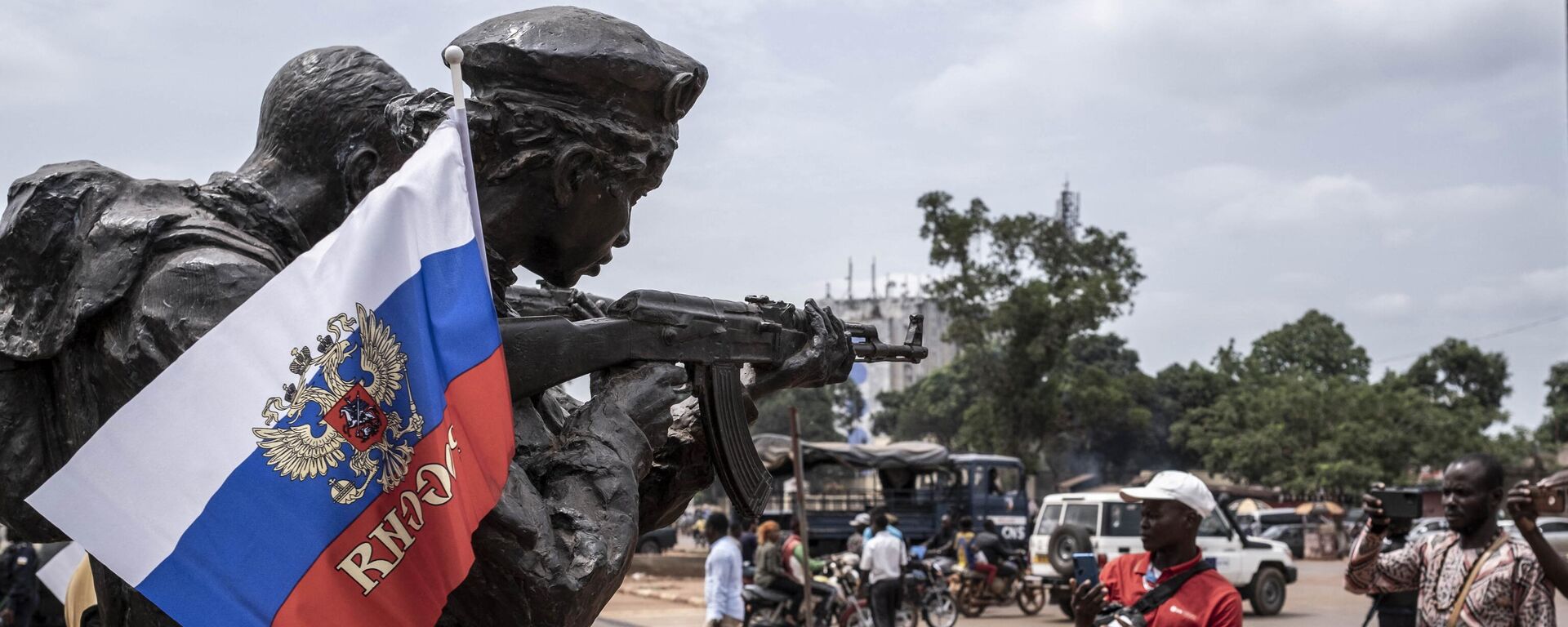A Russian flag with the emblem of Russia on hang on the monument of the Russian instructors in Bangui, on March 22, 2023 during a march in support of Russia and China's presence in the Central African Republic.  - Sputnik Africa, 1920, 01.01.2024