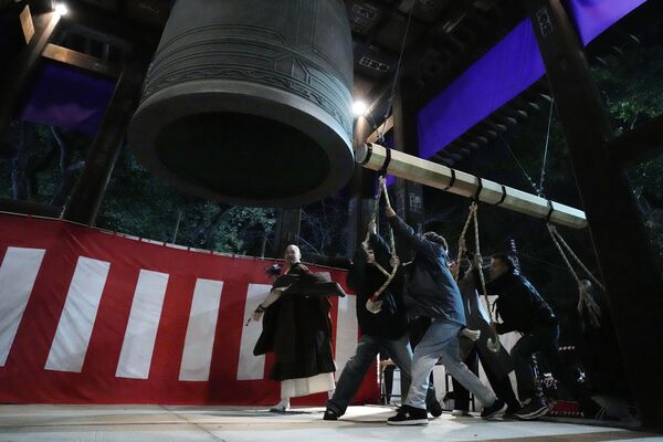 People strike a giant bell to celebrate the New Year at the Zojoji Buddhist temple, minutes after midnight Monday, Jan. 1, 2024, in Tokyo, Japan. - Sputnik Africa