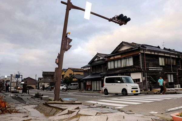 A car drives past a badly damaged pavement along a street in the city of Wajima, Ishikawa prefecture on January 1, 2024, after a major 7.5 magnitude earthquake struck the Noto region in Ishikawa prefecture in the afternoon. - Sputnik Africa