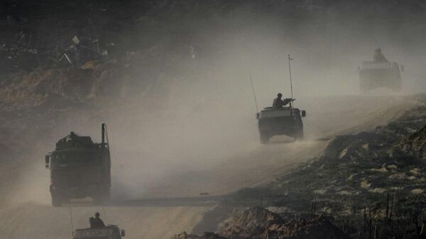 A convoy of Israeli troops moves in the Gaza Strip as seen from southern Israel, Thursday, Jan. 4, 2024.  - Sputnik Africa