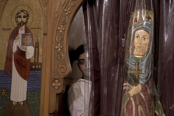 A Coptic Christian peers out of a window during an Orthodox Christmas Eve Mass at the Church of Ava Bishoy and St. Karas the Anchorite in Cairo, Egypt.   - Sputnik Africa