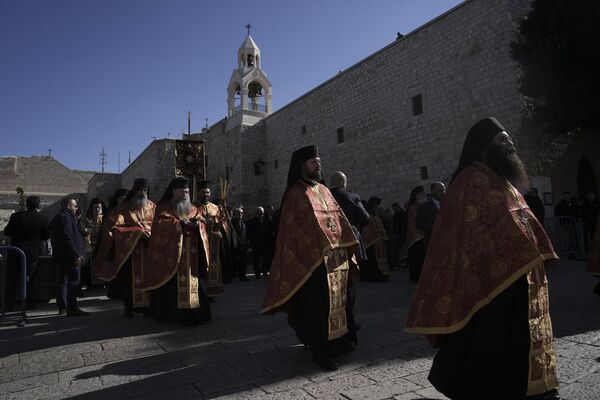 Orthodox priests walk outside the Nativity Church, where Christians believe Jesus Christ was born on the eve of the Orthodox Christmas in Bethlehem, West Bank. - Sputnik Africa