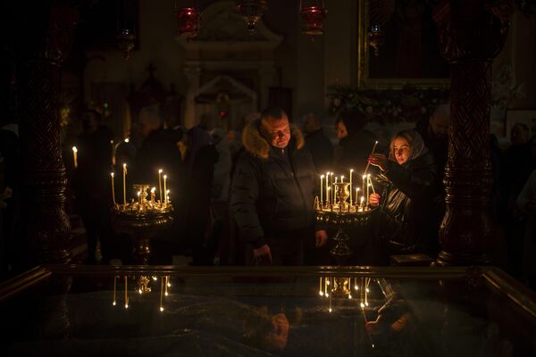 Lithuanian Orthodox Church worshippers light candles before the liturgy on Orthodox Christmas Eve in the Orthodox Church of the Holy Spirit in Vilnius, Lithuania. - Sputnik Africa