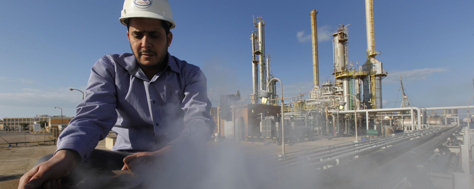 In this Feb. 26, 2011 file photo, a Libyan oil works at a refinery inside the Brega oil complex, in Brega, eastern Libya.  - Sputnik Africa, 1920, 08.01.2024