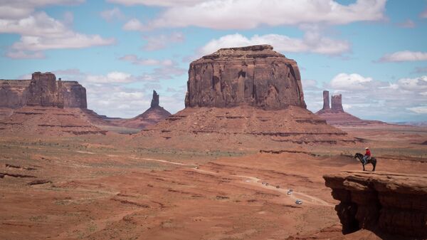 A Navajo man on a horse poses for tourists in front of the Merrick Butte in Monument Valley Navajo Tribal park, Utah, on May 12, 2014 - Sputnik Africa