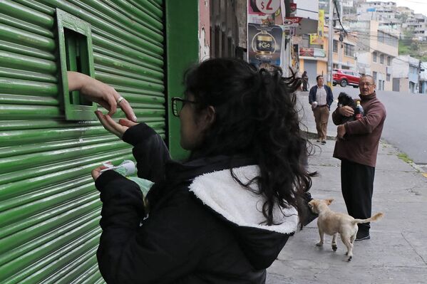 A woman buys a product through a small window in a metal curtain in downtown Quito on January 9, 2024, amid growing tension after Ecuadorean President Daniel Noboa declared the country in a state of &quot;internal armed conflict&quot; and ordered the army to carry out military operations against the country&#x27;s powerful drug gangs. - Sputnik Africa