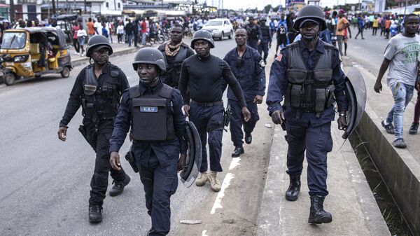 Liberian police officers walk towards clashes that broke out between supporters of Liberian President George Weah and his political party Congress for Democratic Change (CDC) and opposition parties during a final campaign rally in Monrovia, on October 8, 2023. - Sputnik Africa