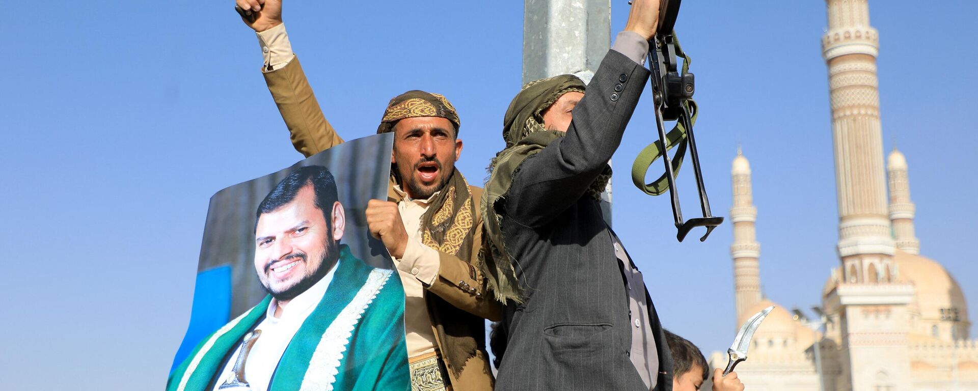 Houthi fighters, one holding a portrait of Houthi leader Abdul Malik al-Houthi (L), brandish their weapons during a protest following US and British forces strikes, in the Houthi-controlled capital Sanaa on January 12, 2024, amid the ongoing battles between Israel and the militant Hamas group in Gaza. - Sputnik Africa, 1920, 12.01.2024