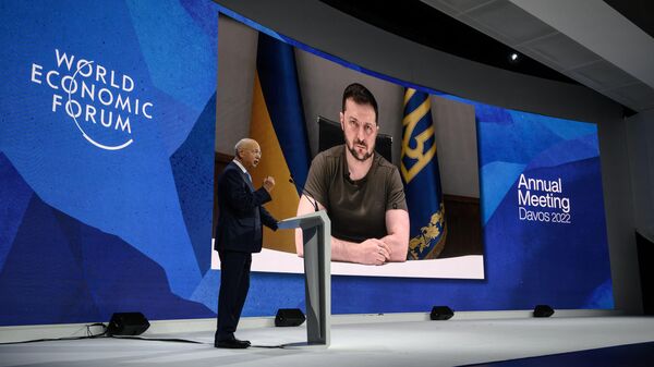  Founder and executive chairman of the World Economic Forum Klaus Schwab welcomes Ukrainian President Volodymyr Zelensky seen on a giant screen by video link at the Congress centre during the World Economic Forum (WEF) annual meeting in Davos on May 23, 2022. Zelensky is similarly expected to attend the WEF's 2024 meetings this week. - Sputnik Africa