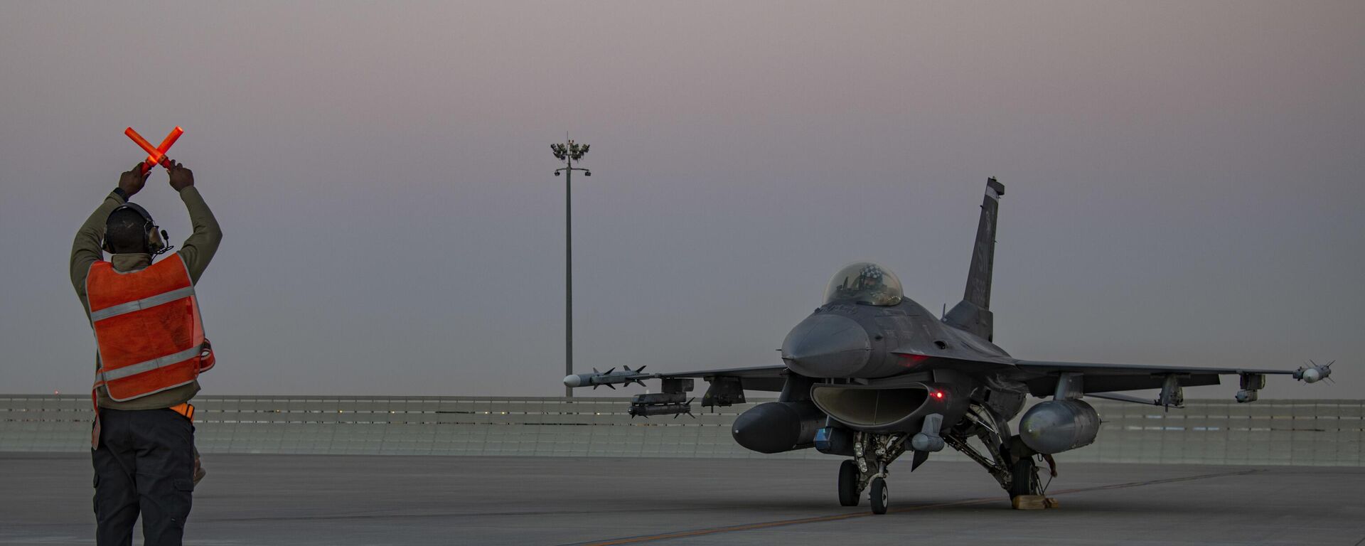 In this handout photo from the U.S. Air Force, an airman guides an F-16 Fighting Falcon during training at Al-Udeid Air Base, Qatar, Jan. 24, 2022.  - Sputnik Africa, 1920, 16.01.2024