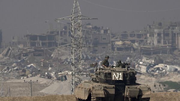 Israeli soldiers overlook the Gaza Strip from a tank, as seen from southern Israel, Friday, Jan. 19, 2024.  - Sputnik Afrique