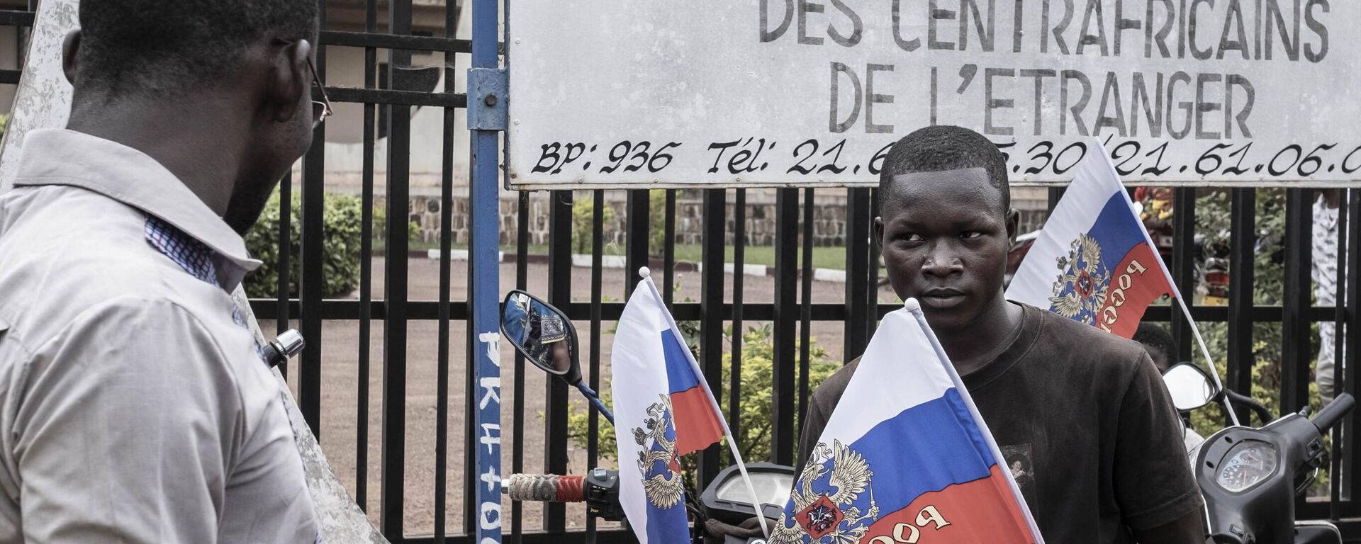 A demonstrator holds a Russian flag with the emblem of Russia on while sitting on a motorcycle in Bangui, on March 22, 2023 during a march in support of Russia and China's presence in the Central African Republic. - Sputnik Africa, 1920, 26.01.2024