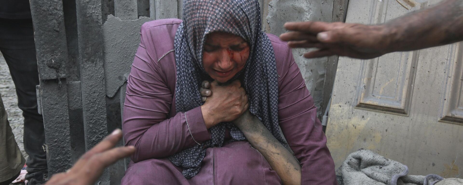 A wounded Palestinian woman cries as she holds the hand of her dead relative outside her home following Israeli airstrikes that targeted their neighbourhood in Gaza City, Monday, Oct. 23, 2023. - Sputnik Africa, 1920, 28.02.2024