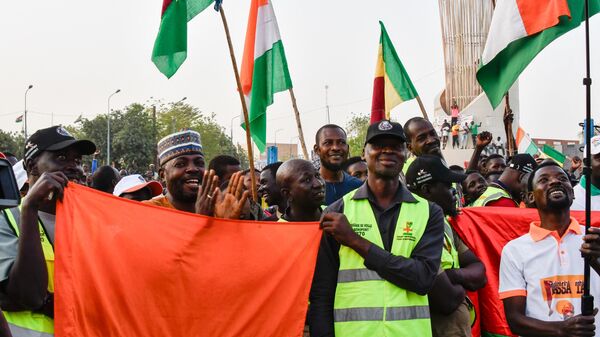 Supporters of the Alliance Of Sahel States (AES) hold up flags as they celebrate Mali, Burkina Faso and Niger leaving the Economic Community of West African States (ECOWAS) in Niamey on January 28, 2024.  - Sputnik Africa