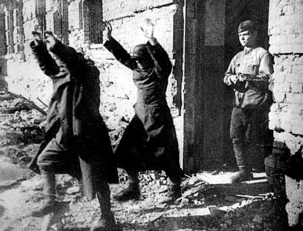 Two Axis soldiers, with their hands held above their heads, are marched out of a battered building by one of their Russian captors as German soldiers are evicted from Stalingrad on Jan. 25, 1943 during World War II.  - Sputnik Africa