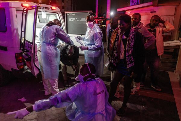 TOPSHOT - Medical responders tend to an injured man as others queue for aid next to an ambulance following a series of explosions in the Embakasi area of Nairobi, Kenya on February 2, 2024.  - Sputnik Africa