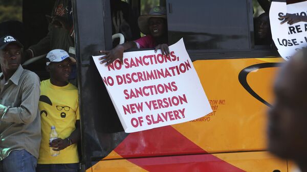 A woman on a bus holds a placard while protesting over US sanctions that the Zimbabwean government blames for the country's worsening economic problems, in Harare, Friday, Oct, 25, 2019. - Sputnik Afrique