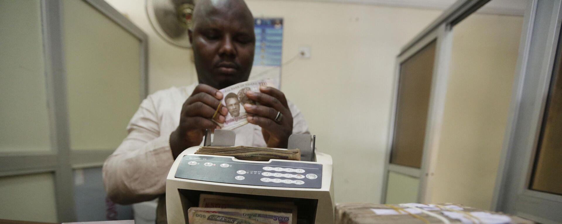 A money changer counts Nigerian naira currency at an exchange office, in Lagos, Nigeria, Oct. 20, 2015. - Sputnik Africa, 1920, 07.02.2024