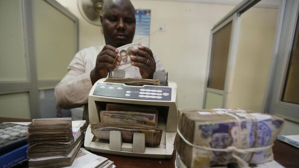 A money changer counts Nigerian naira currency at an exchange office, in Lagos, Nigeria, Oct. 20, 2015. - Sputnik Africa