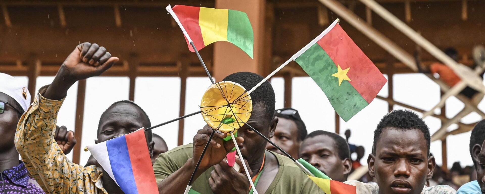 A supporter of Niger's National Council for Safeguard of the Homeland (CNSP) holds national flags of Mali, Burkina Faso, Algeria, Niger and Russia as they gather at the general Seyni Kountche stadium in Niamey on Agust 26, 2023.  - Sputnik Africa, 1920, 12.02.2024