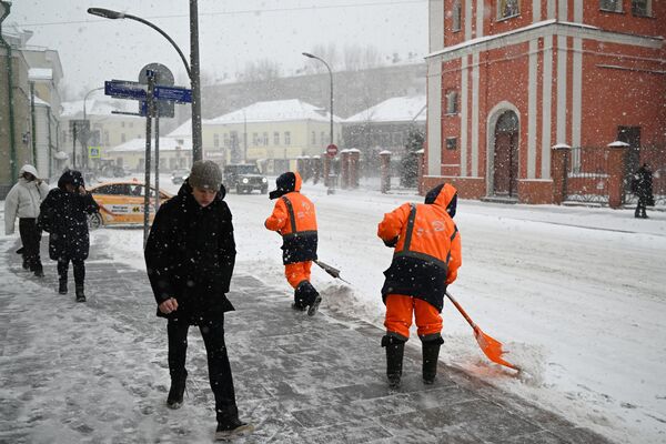 People cross the street during snowfall in Moscow. - Sputnik Africa