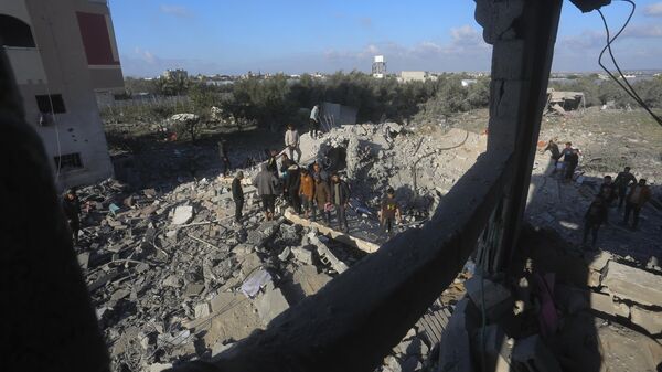 Palestinians search for survivors after an Israeli airstrike on a residential building In Rafah - Sputnik Afrique