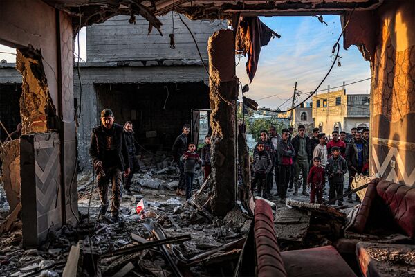 People inspect debris and rubble in a building heavily damaged by Israeli bombardment, in Rafah in the southern Gaza Strip on February 11, 2024, amid the ongoing conflict between Israel and the Palestinian militant group Hamas. - Sputnik Africa