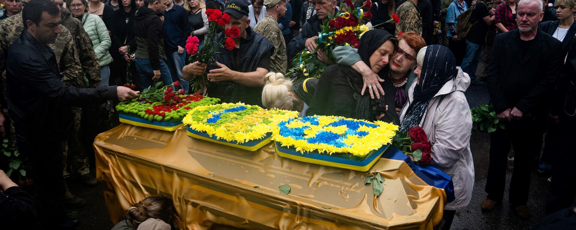 Relatives and friends take part in a funeral service of the Ukrainian Lance Sergeant Yulian Matviychuk, who died from his wounds in the Donetsk region, during funeral in Poltava, on May 23, 2023. - Sputnik Africa, 1920, 13.02.2024