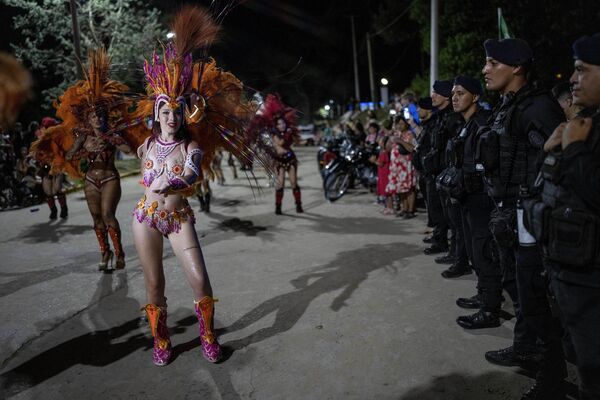 Police stand in line as revelers parade during carnival celebrations in Villa Gesell, Buenos Aires province, Argentina, Sunday, Feb. 11, 2024. - Sputnik Africa