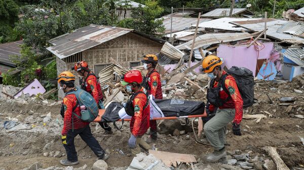 Rescuers carry a body from the landslide-hit village of Masara in Maco, Davao de Oro province, southern Philippines - Sputnik Africa