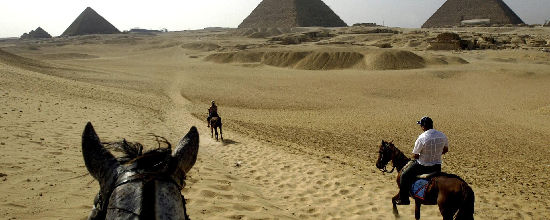 Tourists ride horses towards the Khafre Pyramid, center the Khufu Pyramid, right and the Menkaure Pyramid at the historical site of Giza near Cairo, Egypt, on Tuesday, June 13, 2006. - Sputnik Africa, 1920, 18.02.2024