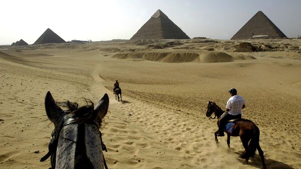 Tourists ride horses towards the Khafre Pyramid, center the Khufu Pyramid, right and the Menkaure Pyramid at the historical site of Giza near Cairo, Egypt, on Tuesday, June 13, 2006. - Sputnik Africa