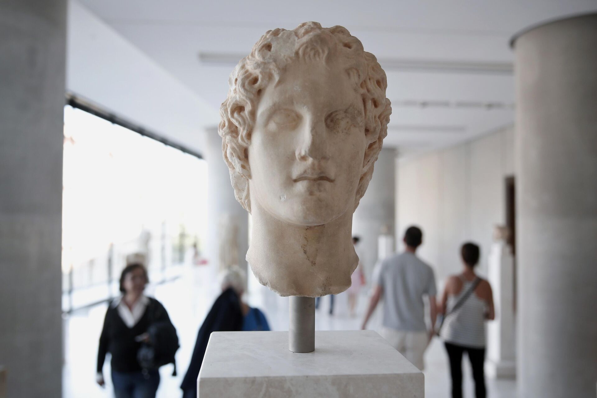 Visitors walk behind an ancient marble head of ancient Greek warrior-king Alexander the Great, displayed at the Acropolis museum in Athens, Oct. 12, 2014. Alexander the Great was one of the world's most successful military commanders, who enlarged his father's kingdom to include an empire stretching from modern Greece to India. During his youth, Alexander was tutored by the ancient Greek philosopher Aristotle until the age of 16.  - Sputnik Africa, 1920, 17.02.2024