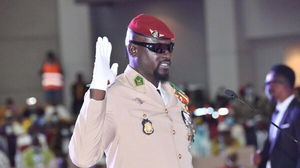 Guinea junta leader Colonel Mamady Doumbouya, raises his hand at his swearing in ceremony as president of country transion on October 1, 2021 in Conakry.  - Sputnik Africa
