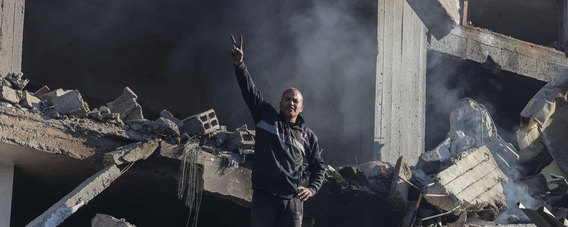 A Palestinian man gestures as he stands amid debris of a building on February 22, 2024, following an overnight Israeli air strike in Rafah refugee camp in the southern Gaza Strip, as battles between Israel and the Palestinian militant group Hamas continue. - Sputnik Africa, 1920, 22.02.2024
