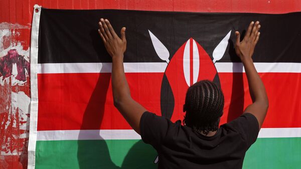 A student adjusts a Kenyan national flag as he and others take part in a vigil for students killed in an attack by Islamic militants in Garissa, Kenya, at the University of Cape Town, in Cape Town, South Africa, Monday, April 6, 2015. - Sputnik Africa
