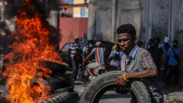 A protester adds a tire to a pile set on fire during the protest against rising fuel prices, in Port-au-Prince, Haiti, December 10, 2021. - Sputnik Africa