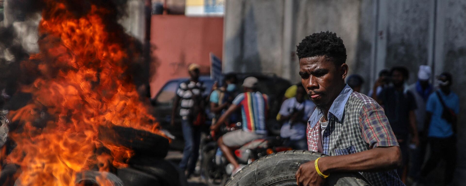 A protester adds a tire to a pile set on fire during the protest against rising fuel prices, in Port-au-Prince, Haiti, December 10, 2021. - Sputnik Africa, 1920, 27.02.2024