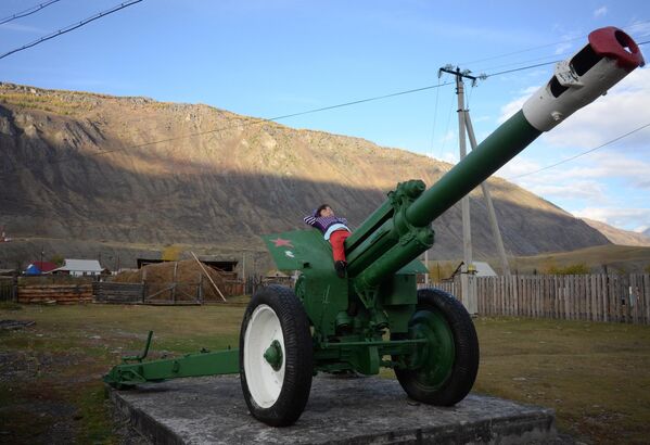 A girl sleeps on a cannon-monument to the heroes of the World War II in the village of Chibit in the Altai Republic, Russia. - Sputnik Africa