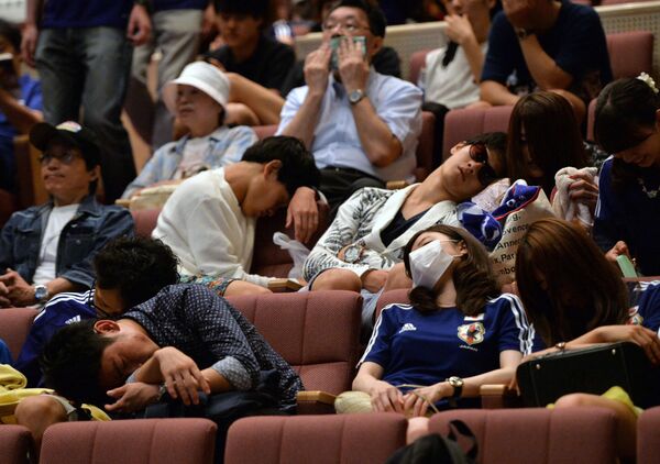 Japanese football supporters sleep before a 2014 FIFA World Cup group C match between Japan and Greece at a public viewing in Tokyo on June 20, 2014. - Sputnik Africa