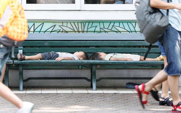 Two children sleep on a bench on the shade at Toshimaen amusement park in Tokyo, 28 July 2007.  - Sputnik Africa