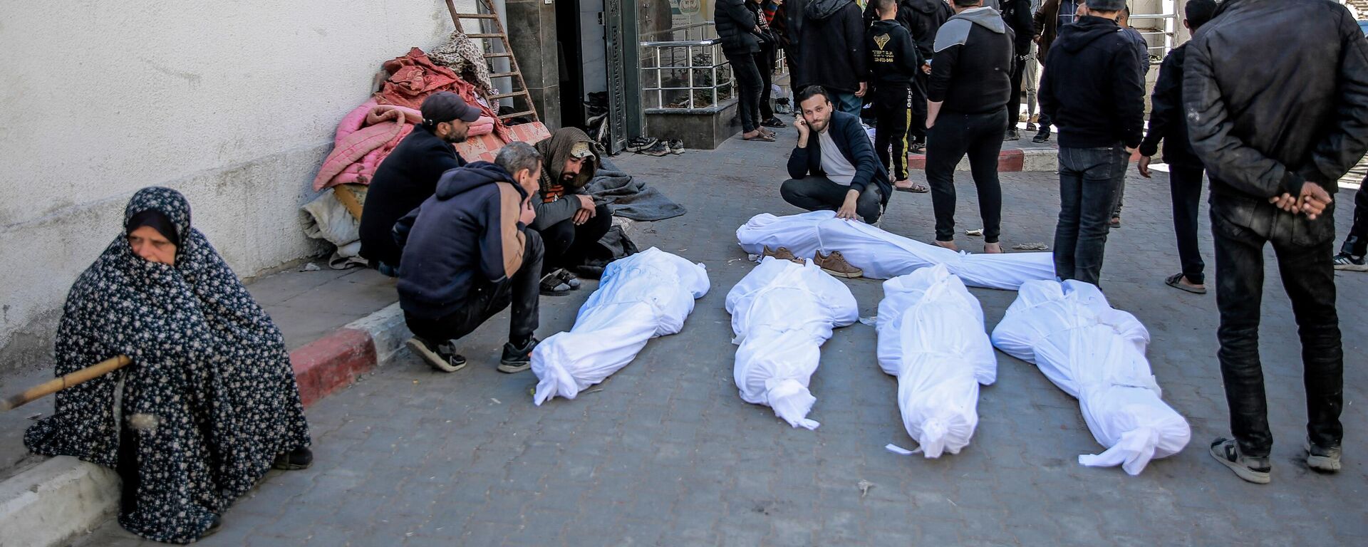 People mourn at Al-Shifa hospital in Gaza City, over the bodies of Palestinians killed in an early morning incident when residents rushed toward aid trucks in Gaza City on February 29, 2024.  - Sputnik Africa, 1920, 01.03.2024